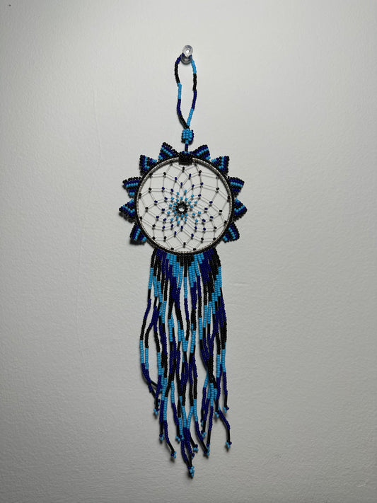 These dream catchers are a beaded hanging ornament, It is handmade and perfect for a wall or for a rear view mirror. This dream catcher is made by a Mayan Family, from beading artists in Santiago La Laguna in rural Guatemala. Indigenous motifs worked in colorful seed beads embellish the dream catcher. Bead work is relatively new in Guatemala, but the impact of its trade makes a tremendous positive difference in the lives of the indigenous women who have learned this intricate skill.