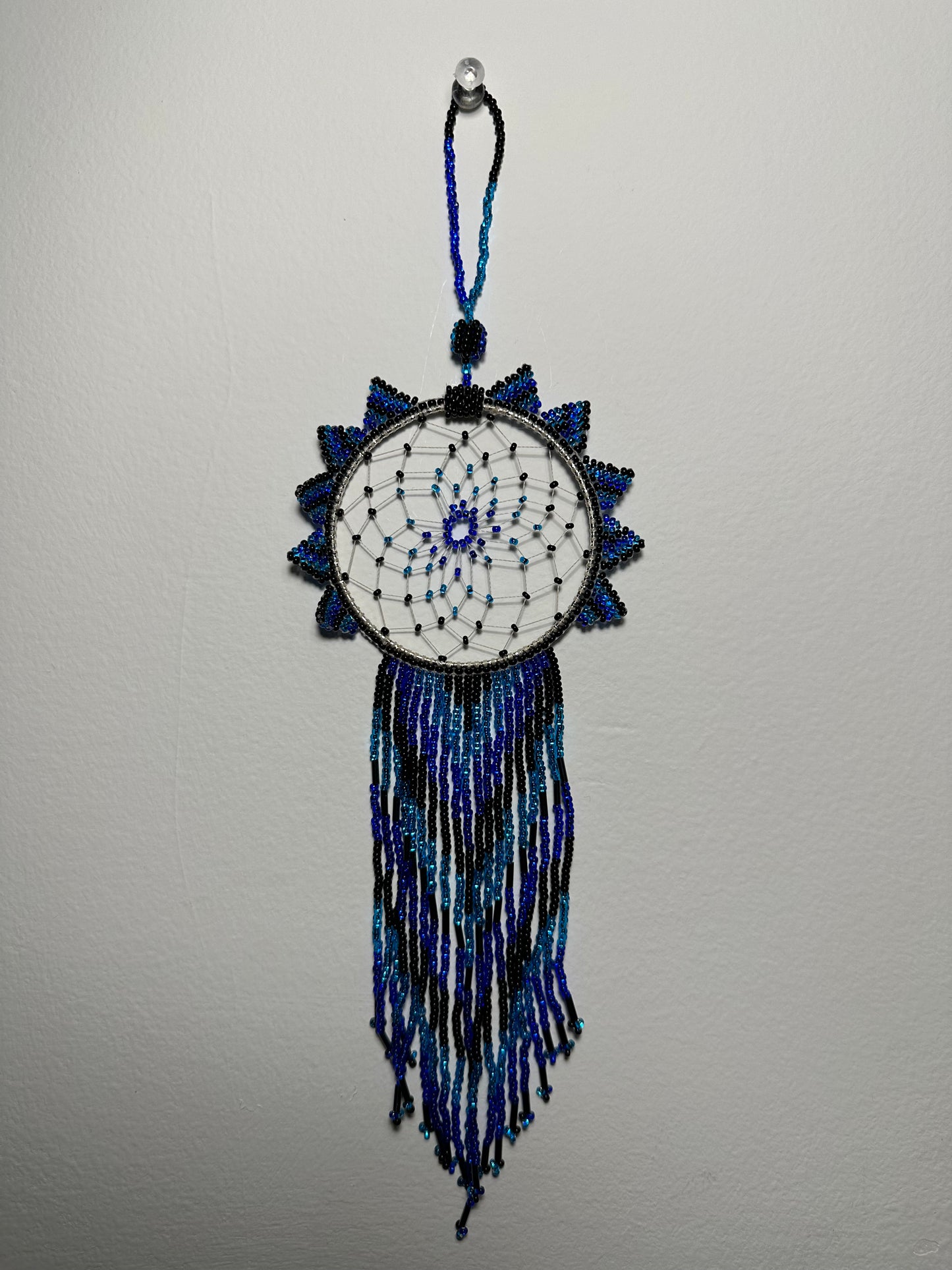 These dream catchers are a beaded hanging ornament, It is handmade and perfect for a wall or for a rear view mirror. This dream catcher is made by a Mayan Family, from beading artists in Santiago La Laguna in rural Guatemala. Indigenous motifs worked in colorful seed beads embellish the dream catcher. Bead work is relatively new in Guatemala, but the impact of its trade makes a tremendous positive difference in the lives of the indigenous women who have learned this intricate skill.