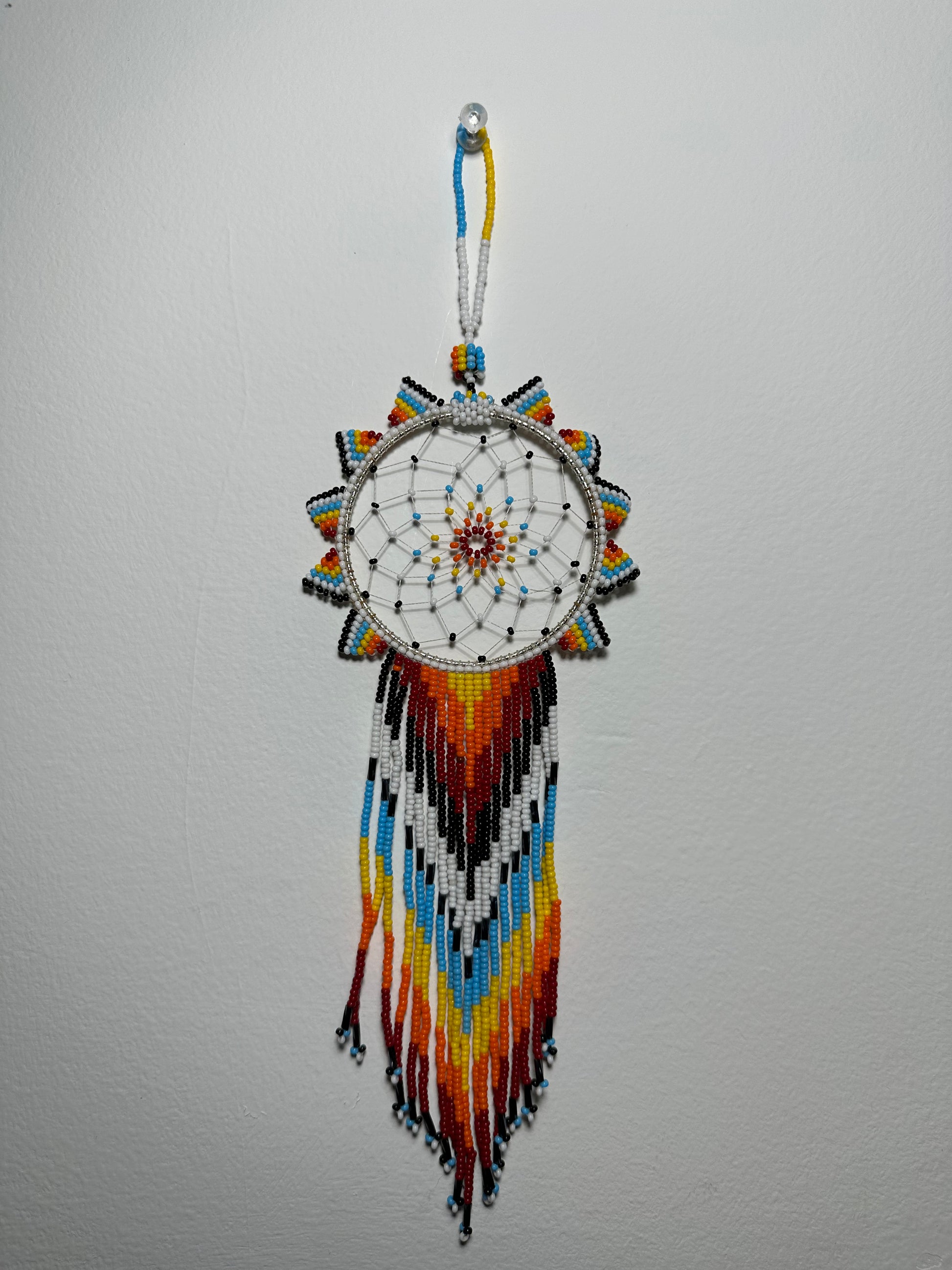 These dream catchers are a beaded hanging ornament, It is handmade and perfect for a wall or for a rear view mirror. This dream catcher is made by a Mayan Family, from beading artists in Santiago La Laguna in rural Guatemala. Indigenous motifs worked in colorful seed beads embellish the dream catcher. Bead work is relatively new in Guatemala, but the impact of its trade makes a tremendous positive difference in the lives of the indigenous women who have learned this intricate skill.