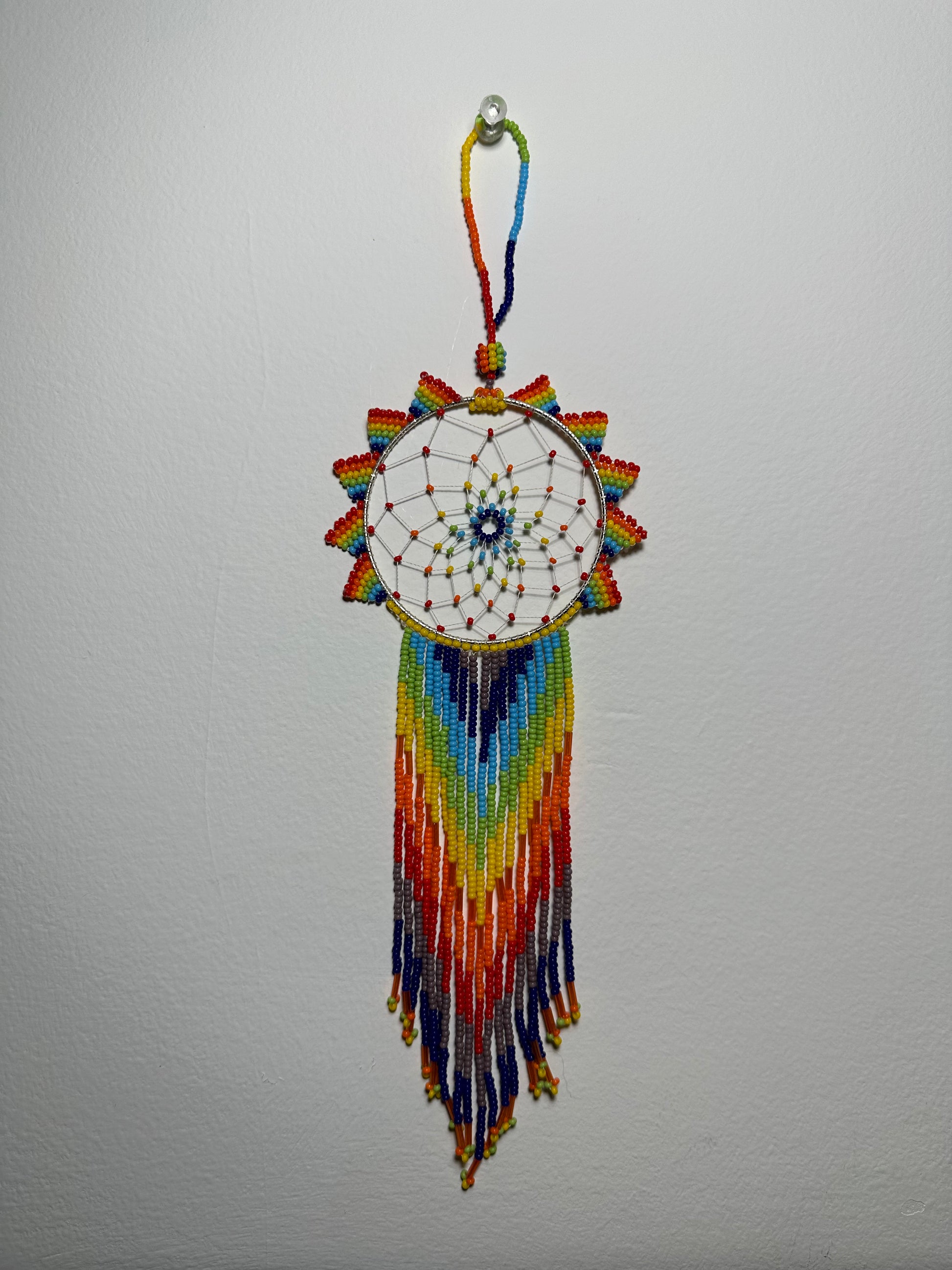 These dream catchers are a beaded hanging ornament, It is handmade and perfect for a wall or for a rear view mirror. This dream catcher is made by a Mayan Family, from beading artists in Santiago La Laguna in rural Guatemala. Indigenous motifs worked in colorful seed beads embellish the dream catcher. Bead work is relatively new in Guatemala, but the impact of its trade makes a tremendous positive difference in the lives of the indigenous women who have learned this intricate skill.