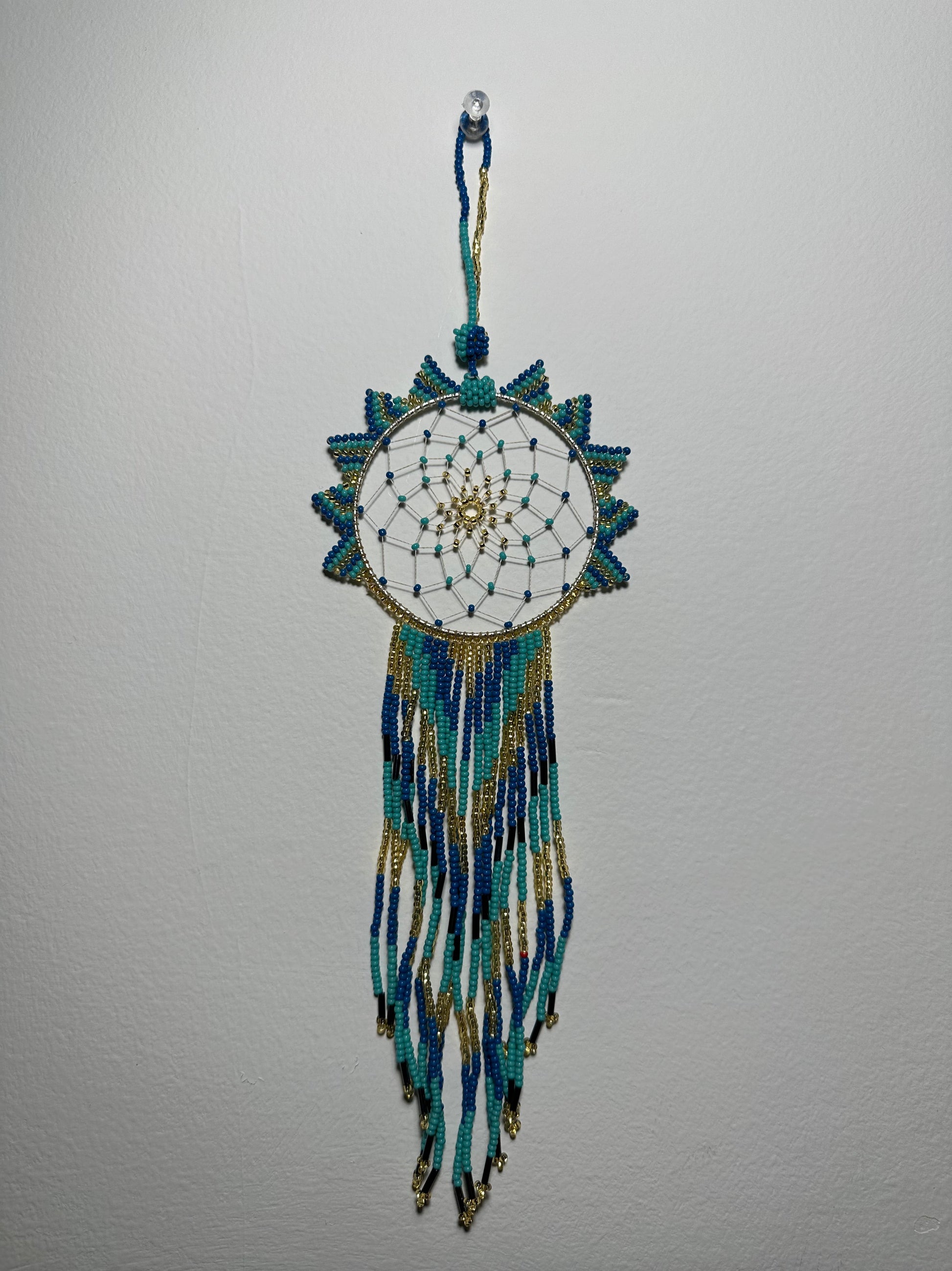 These dream catchers are a beaded hanging ornament, It is handmade and perfect for a wall or for a rear view mirror. This dream catcher is made by a Mayan Family, from beading artists in Santiago La Laguna in rural Guatemala. Indigenous motifs worked in colorful seed beads embellish the dream catcher. Bead work is relatively new in Guatemala, but the impact of its trade makes a tremendous positive difference in the lives of the indigenous women who have learned this intricate skill.