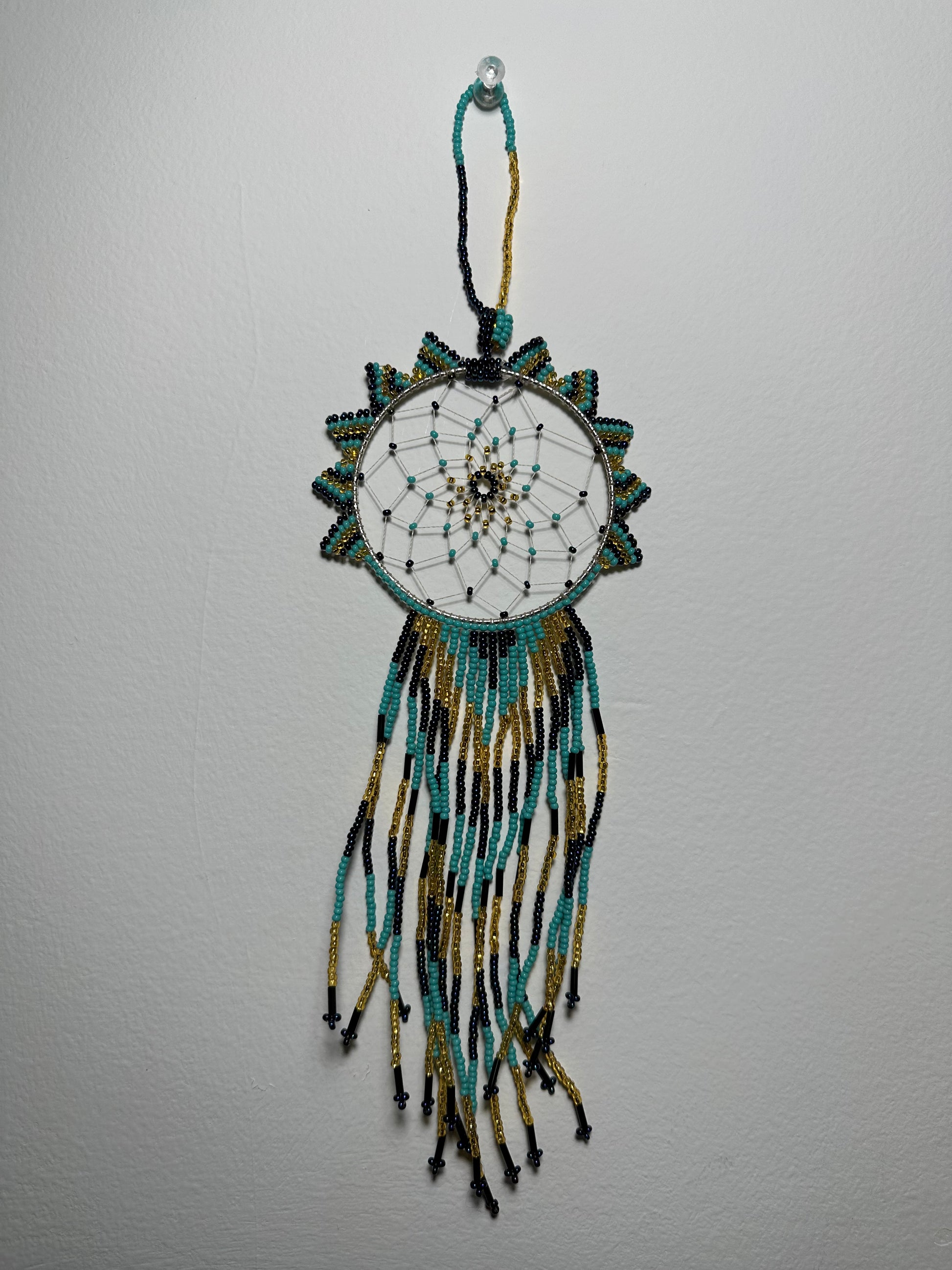 These dream catchers are a beaded hanging ornament, It is handmade and perfect for a wall or for a rear view mirror. This dream catcher is made by a Mayan Family, from beading artists in Santiago La Laguna in rural Guatemala. Indigenous motifs worked in colorful seed beads embellish the dream catcher. Bead work is relatively new in Guatemala, but the impact of its trade makes a tremendous positive difference in the lives of the indigenous women who have learned this intricate skill.