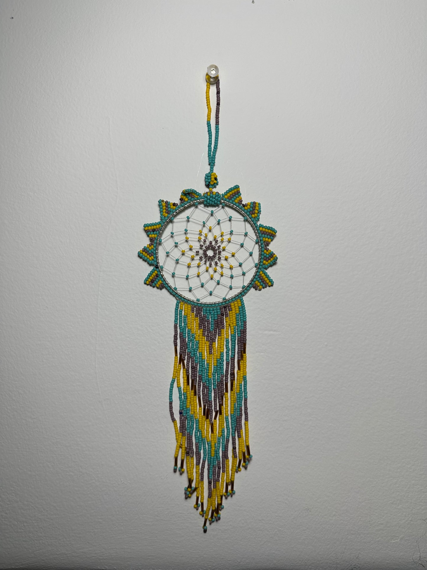 These dream catchers are a beaded hanging ornament, It is handmade and perfect for a wall or for a rear view mirror. This dream catcher is made by a Mayan Family, from beading artists in Santiago La Laguna in rural Guatemala. Indigenous motifs worked in colorful seed beads embellish the dream catcher. Bead work is relatively new in Guatemala, but the impact of its trade makes a tremendous positive difference in the lives of the indigenous women who have learned this intricate skill.