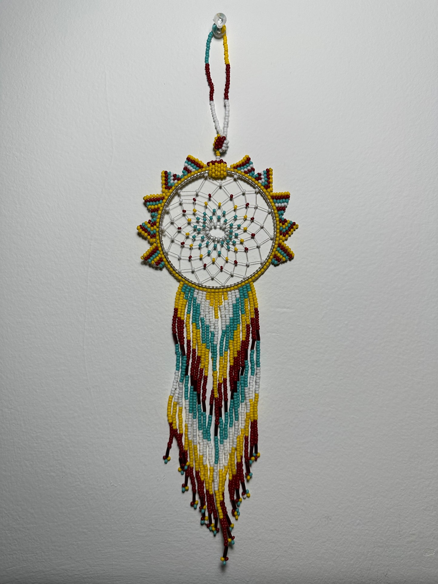 These dream catchers are a beaded hanging ornament, It is handmade and perfect for a wall or for a rear view mirror. This dream catcher is made by a Mayan Family, from beading artists in Santiago La Laguna in rural Guatemala. Indigenous motifs worked in colorful seed beads embellish the dream catcher. Bead work is relatively new in Guatemala, but the impact of its trade makes a tremendous positive difference in the lives of the indigenous women who have learned this intricate skill.