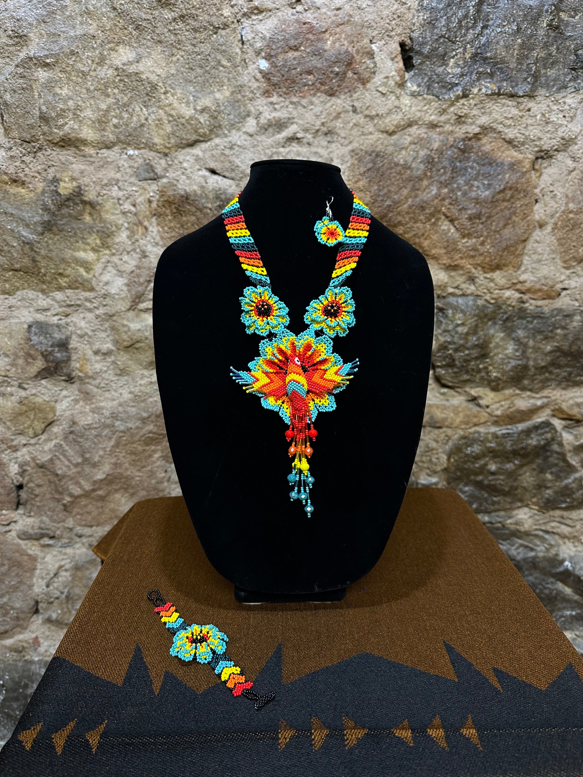 Make a vibrant statement with this handmade Floral Hummingbird Necklace and Earring Set. Crafted with colorful beads, it features a three-dimensional hummingbird motif with intricate detail. Whether you choose to make a statement at a special occasion or just want to add a touch of elegance to your casual look, this set won’t disappoint. With the perfect combination of charm and beauty, this one-of-a-kind set is sure to complement any ensemble.