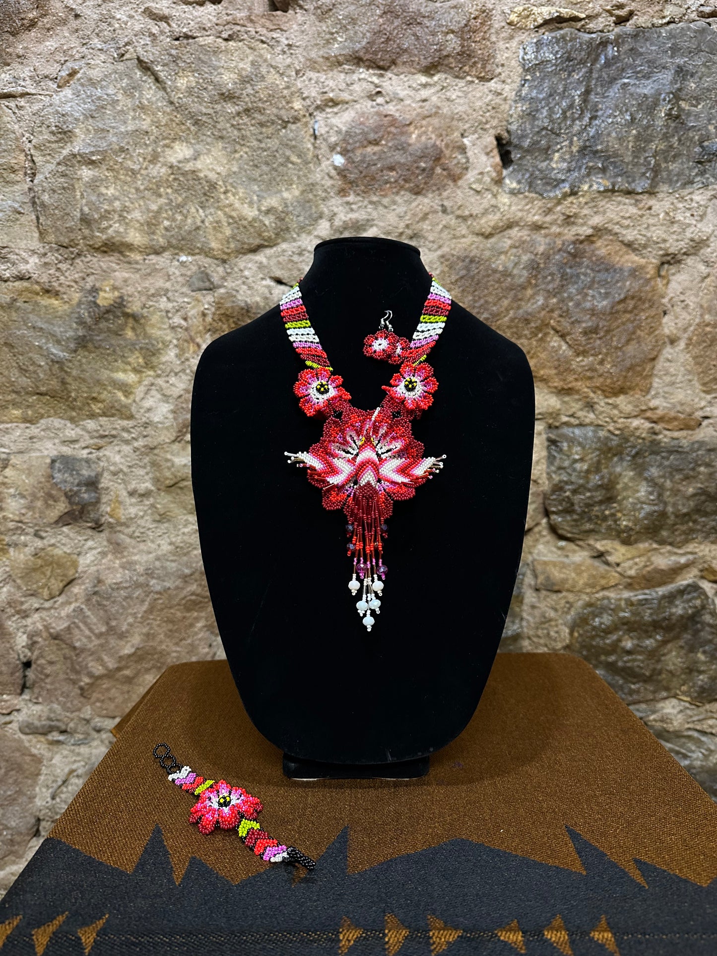 Make a vibrant statement with this handmade Floral Hummingbird Necklace and Earring Set. Crafted with colorful beads, it features a three-dimensional hummingbird motif with intricate detail. Whether you choose to make a statement at a special occasion or just want to add a touch of elegance to your casual look, this set won’t disappoint. With the perfect combination of charm and beauty, this one-of-a-kind set is sure to complement any ensemble.