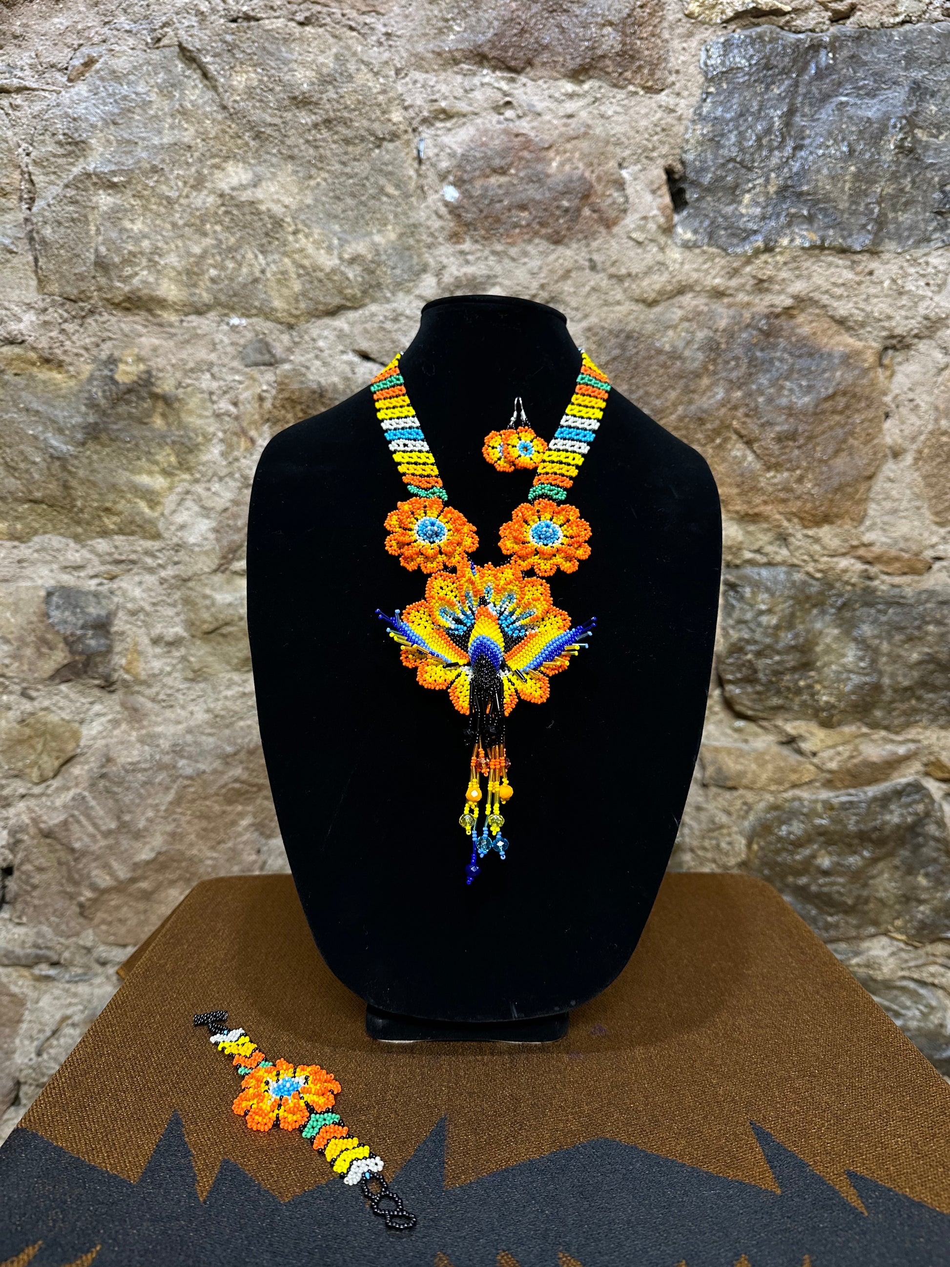 Make a vibrant statement with this handmade Floral Hummingbird Necklace and Earring Set. Crafted with colorful beads, it features a three-dimensional hummingbird motif with intricate detail. Whether you choose to make a statement at a special occasion or just want to add a touch of elegance to your casual look, this set won’t disappoint. With the perfect combination of charm and beauty, this one-of-a-kind set is sure to complement any ensemble.