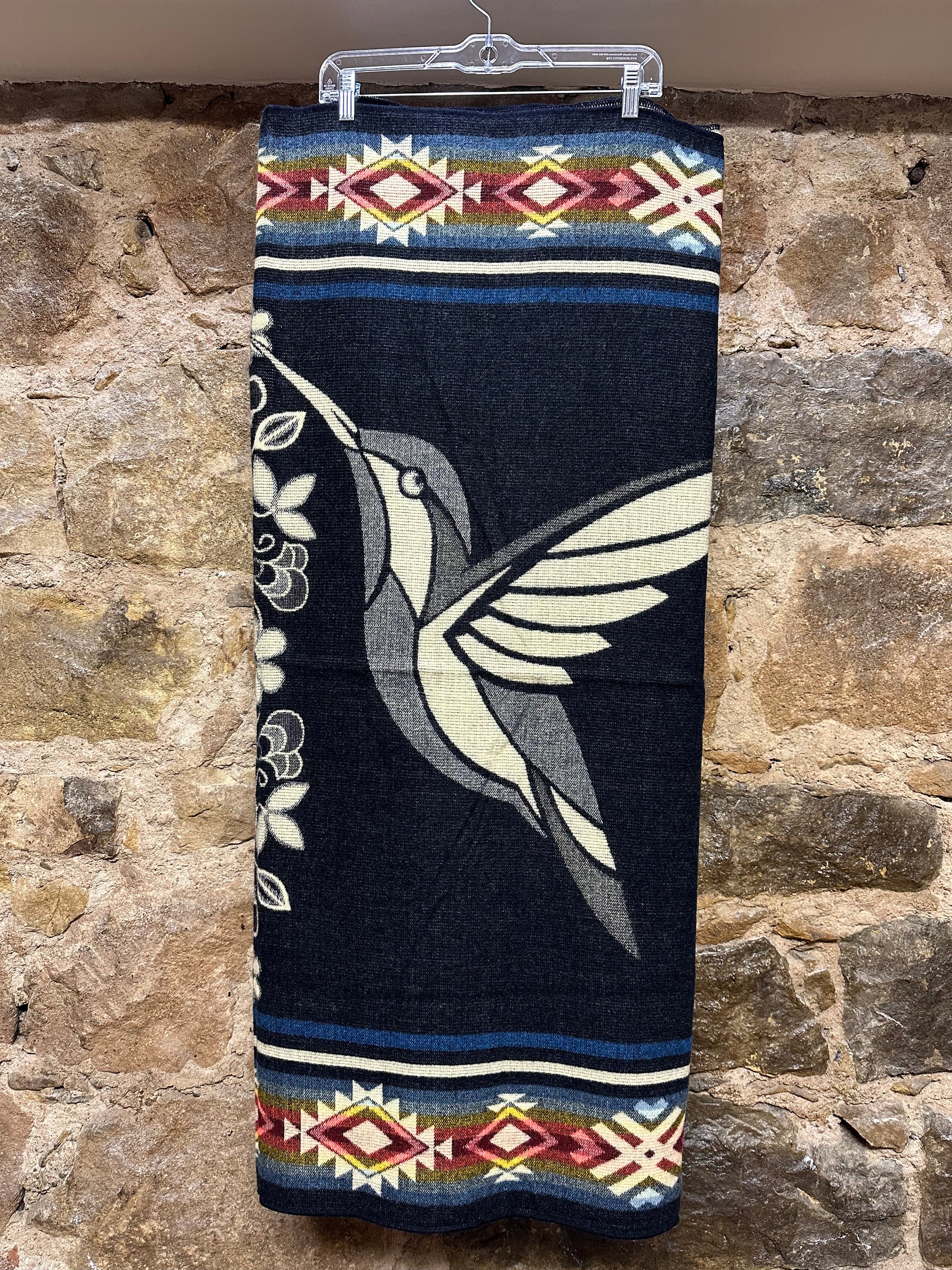 This cozy hummingbird blanket, made in Ecuador, is perfect for snuggling up this winter season! It's soft with a blend of 70% wool and 30% acrylic, keeping you warm and snug wherever you go. Whether you’re cuddling on the sofa, joining a campfire, or just taking an evening stroll, the hummingbird blanket will be the perfect companion and make the experience so much more enjoyable. With its unique design and delicate touch, this fun and festive blanket is sure to be the perfect addition to your home.