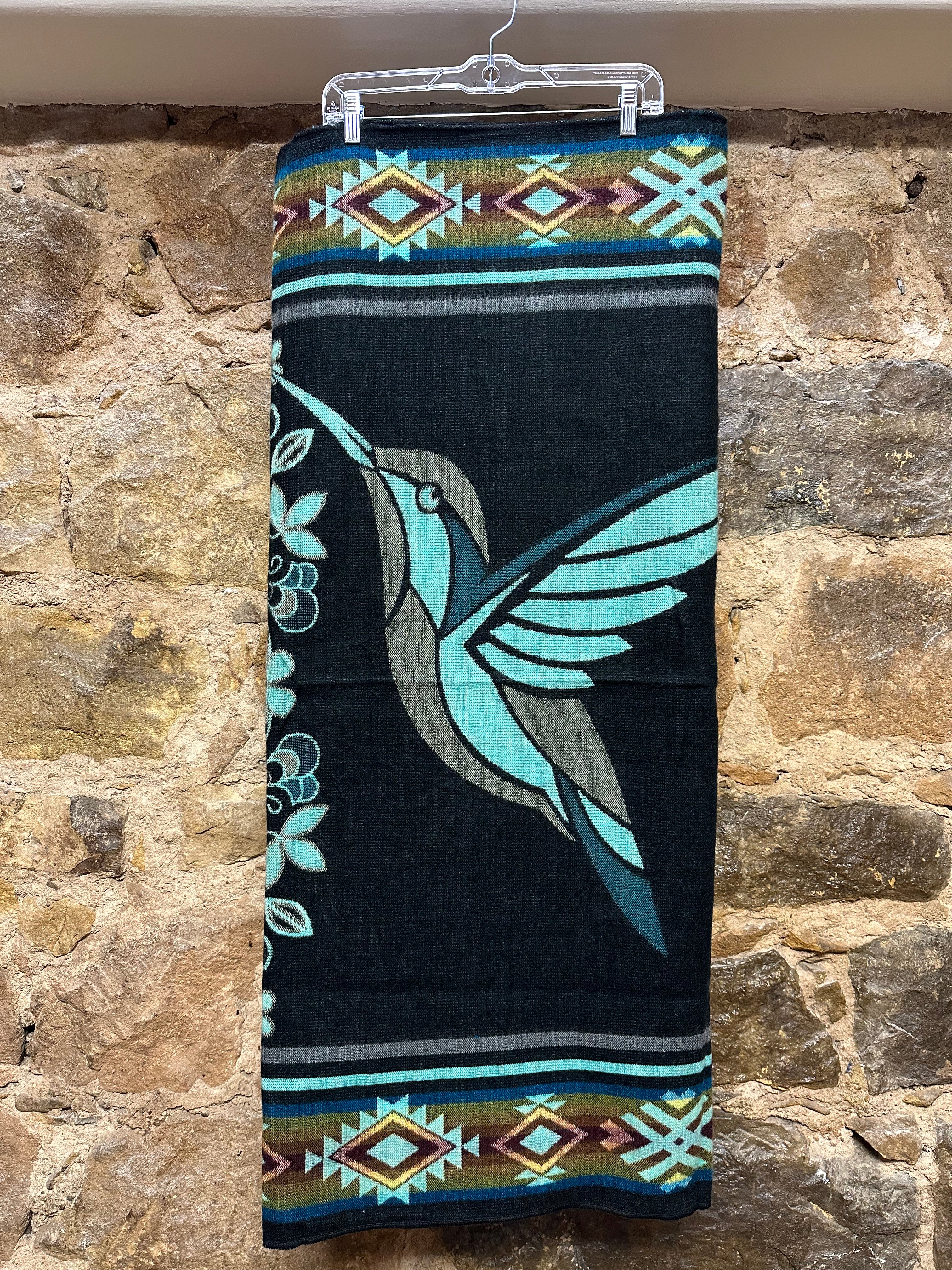 This cozy hummingbird blanket, made in Ecuador, is perfect for snuggling up this winter season! It's soft with a blend of 70% wool and 30% acrylic, keeping you warm and snug wherever you go. Whether you’re cuddling on the sofa, joining a campfire, or just taking an evening stroll, the hummingbird blanket will be the perfect companion and make the experience so much more enjoyable. With its unique design and delicate touch, this fun and festive blanket is sure to be the perfect addition to your home.