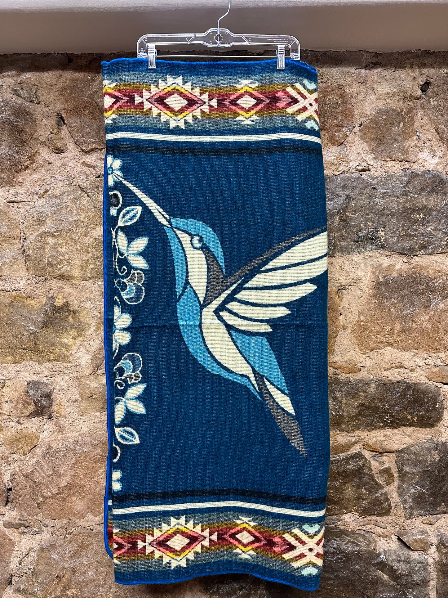 This cozy hummingbird blanket, made in Ecuador, is perfect for snuggling up this winter season! It's soft with a blend of 70% wool and 30% acrylic, keeping you warm and snug wherever you go. Whether you’re cuddling on the sofa, joining a campfire, or just taking an evening stroll, the hummingbird blanket will be the perfect companion and make the experience so much more enjoyable. With its unique design and delicate touch, this fun and festive blanket is sure to be the perfect addition to your home.