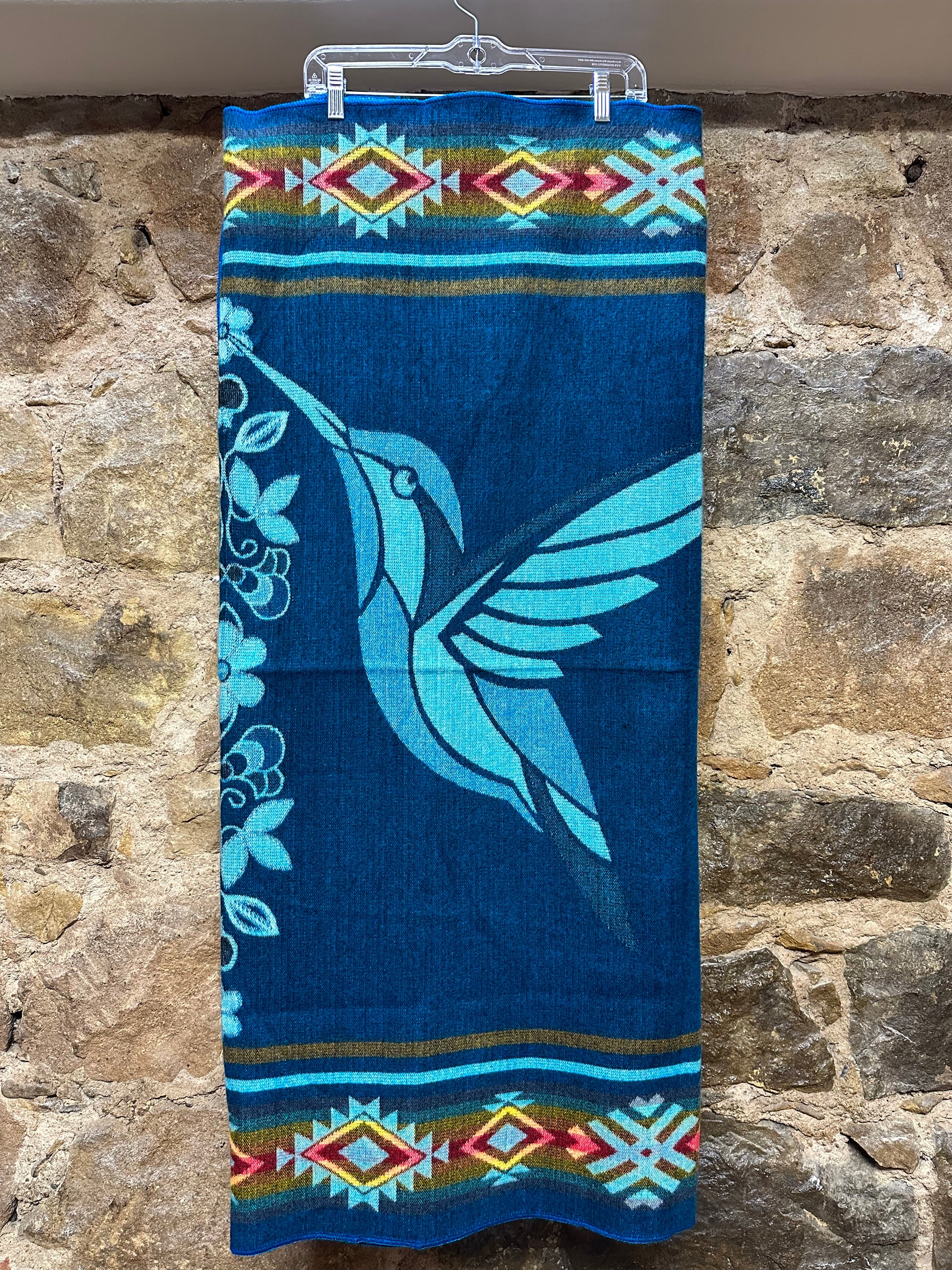 This cozy hummingbird blanket, made in Ecuador, is perfect for snuggling up this winter season! It's soft with a blend of 70% wool and 30% acrylic, keeping you warm and snug wherever you go. Whether you’re cuddling on the sofa, joining a campfire, or just taking an evening stroll, the hummingbird blanket will be the perfect companion and make the experience so much more enjoyable. With its unique design and delicate touch, this fun and festive blanket is sure to be the perfect addition to your home.