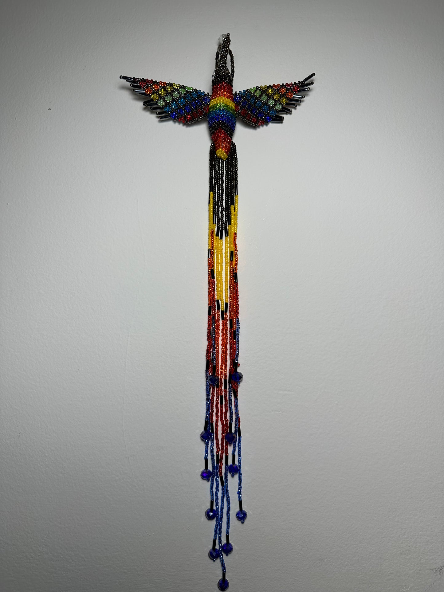 Show off your love of nature with this one-of-a-kind, handmade Guatemalan beaded hummingbird hanging ornament. This whimsical piece is sure to add a touch of joy to your home, garden, or patio. Perfect for those who appreciate unique and handmade designs, this piece is sure to become a treasured part of your space. Add a pop of color and a touch of whimsy to your home today with this beautiful hummingbird hanging ornament.