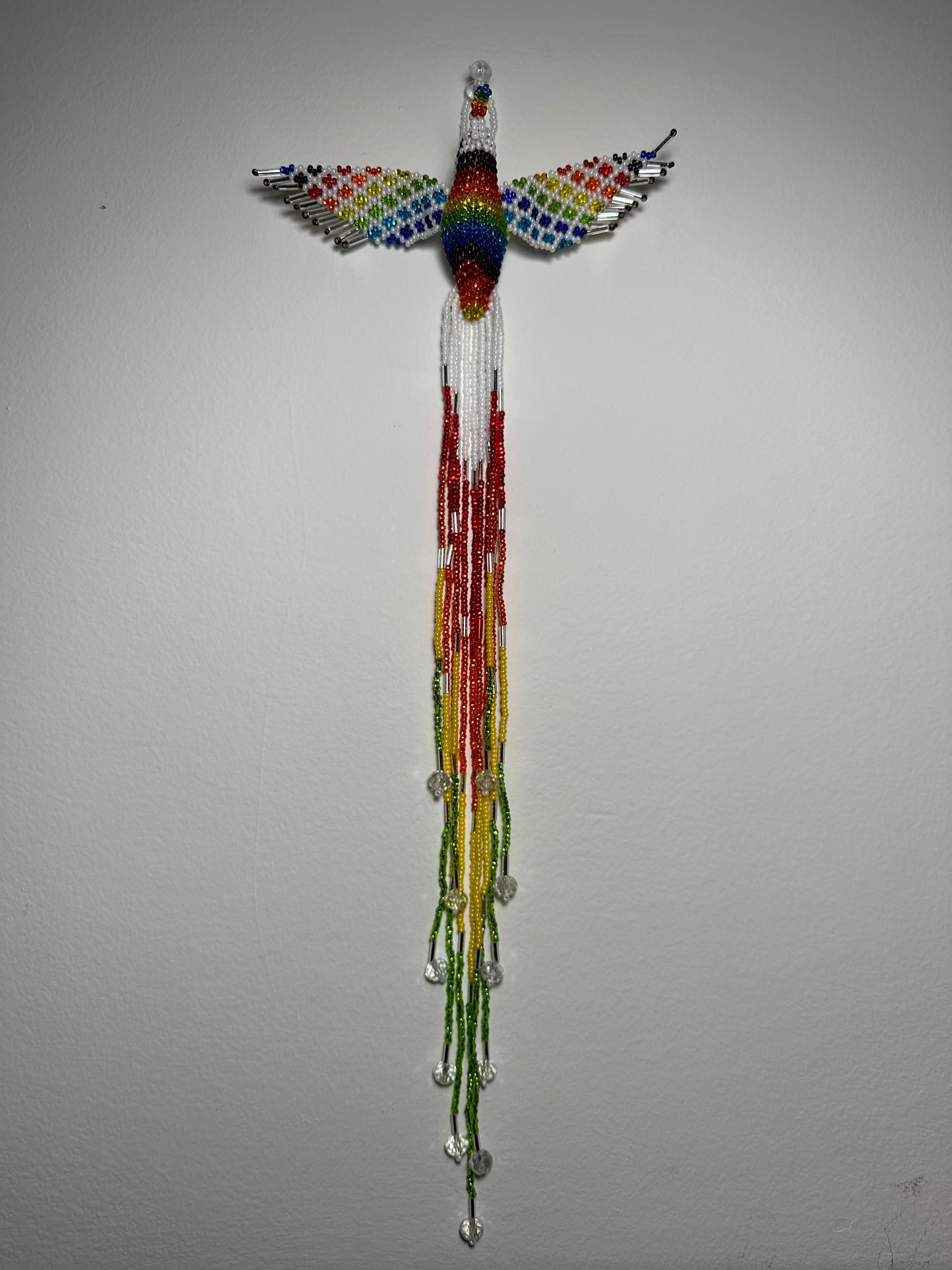 Show off your love of nature with this one-of-a-kind, handmade Guatemalan beaded hummingbird hanging ornament. This whimsical piece is sure to add a touch of joy to your home, garden, or patio. Perfect for those who appreciate unique and handmade designs, this piece is sure to become a treasured part of your space. Add a pop of color and a touch of whimsy to your home today with this beautiful hummingbird hanging ornament.