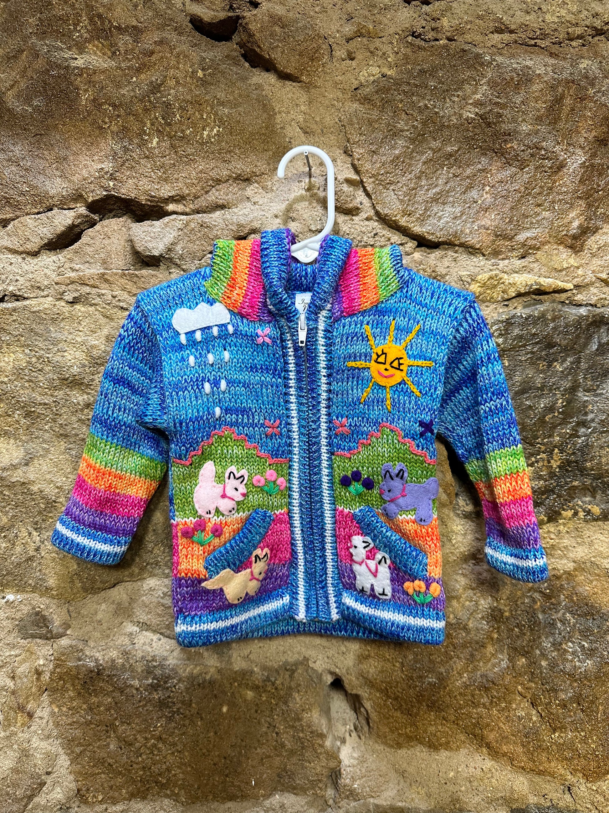 Children's Play Day Sweater! This beautiful, hand-stitched sweater is made with love in Peru and features friendly animals to make any playday special. It will keep your little one warm and cozy while they are out playing and exploring. With vibrant colors and cozy comfort, the Children's Play Day Sweater is perfect for all of your adventures!