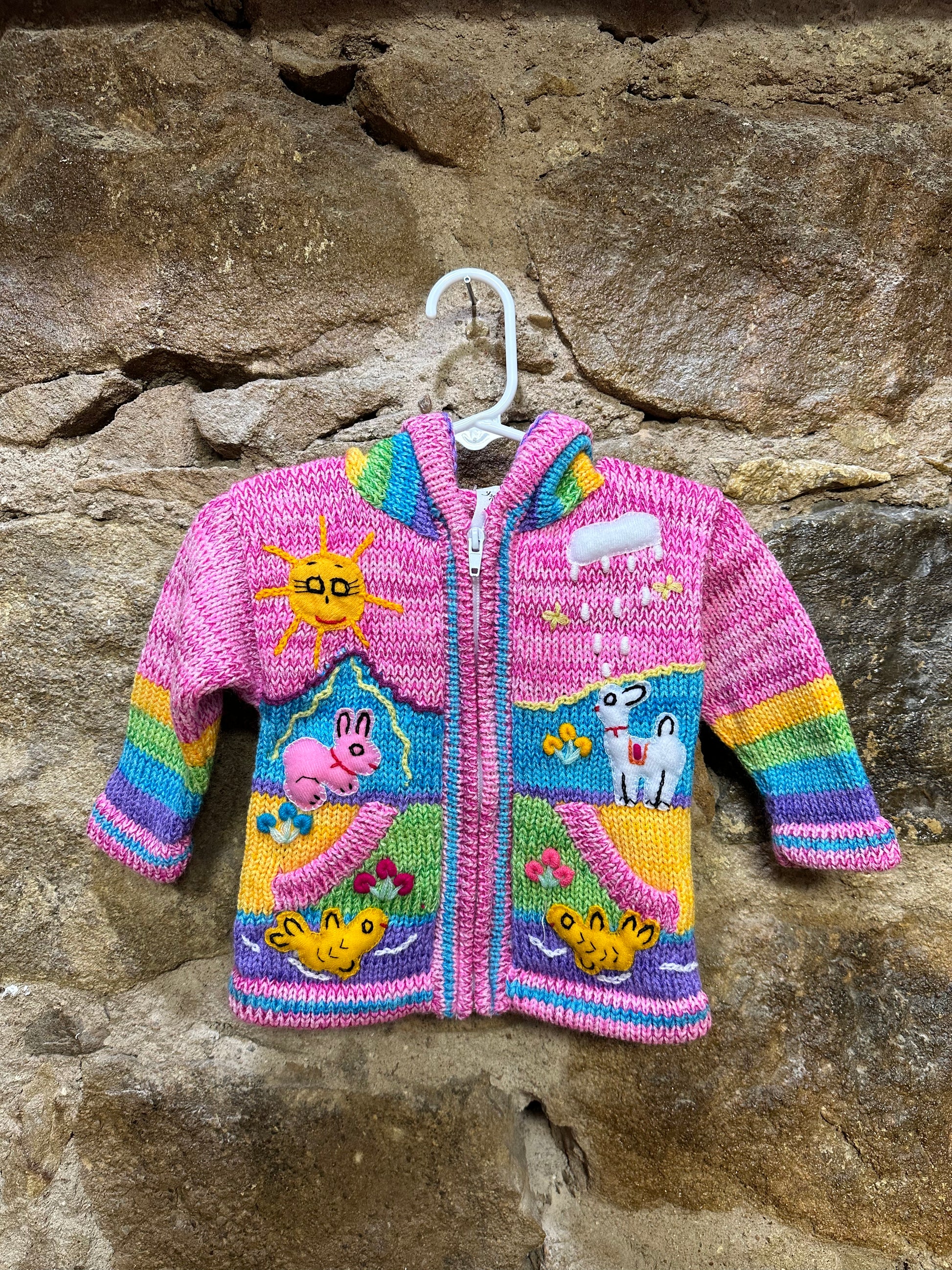 Children's Play Day Sweater! This beautiful, hand-stitched sweater is made with love in Peru and features friendly animals to make any playday special. It will keep your little one warm and cozy while they are out playing and exploring. With vibrant colors and cozy comfort, the Children's Play Day Sweater is perfect for all of your adventures!