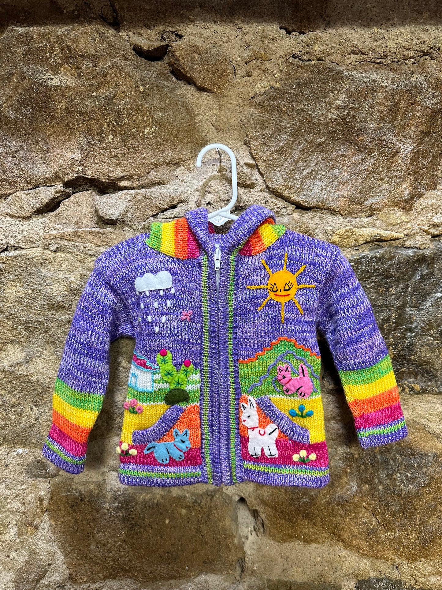 Children's Play Day Sweater! This beautiful, hand-stitched sweater is made with love in Peru and features friendly animals to make any playday special. It will keep your little one warm and cozy while they are out playing and exploring. With vibrant colors and cozy comfort, the Children's Play Day Sweater is perfect for all of your adventures!