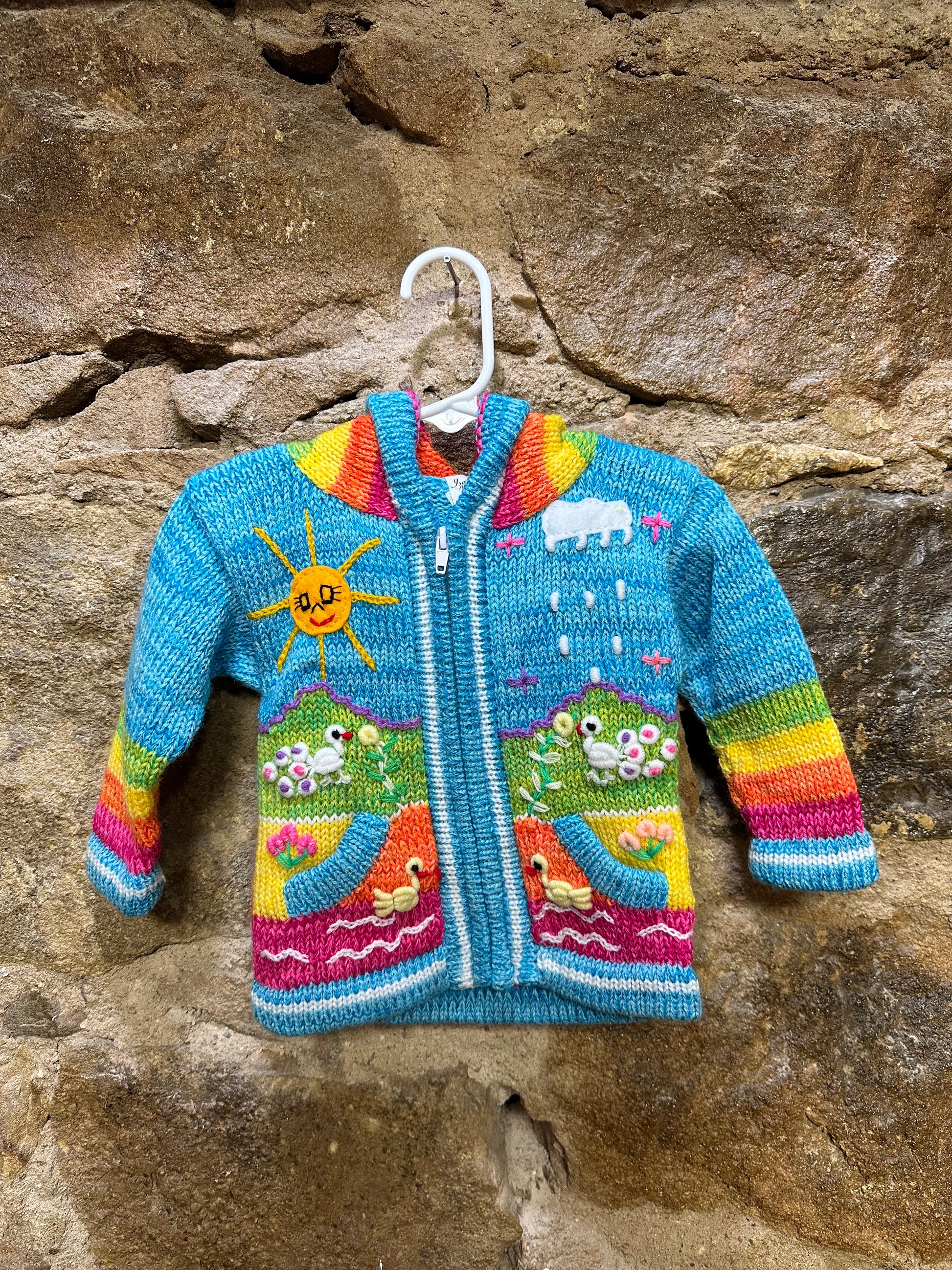 Children's Play Day Sweater! This beautiful, hand-stitched sweater is made with love in Peru and features friendly animals to make any playday special. It will keep your little one warm and cozy while they are out playing and exploring. With vibrant colors and cozy comfort, the Children's Play Day Sweater is perfect for all of your adventures!