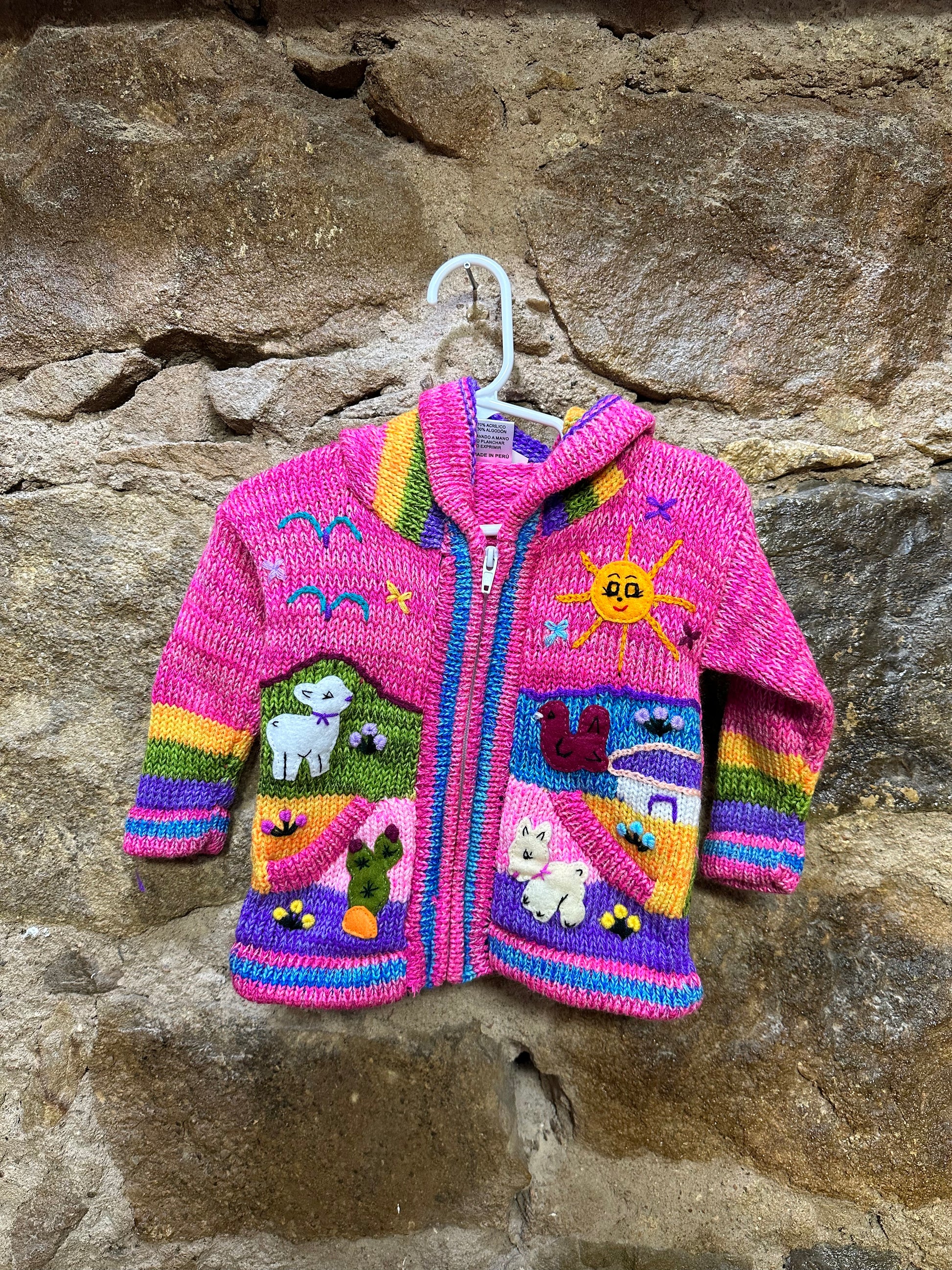 Children's Play Day Sweater! This beautiful, hand-stitched sweater is made with love in Peru and features friendly animals to make any playday special. It will keep your little one warm and cozy while they are out playing and exploring. With vibrant colors and cozy comfort, the Children's Play Day Sweater is perfect for all of your adventures!