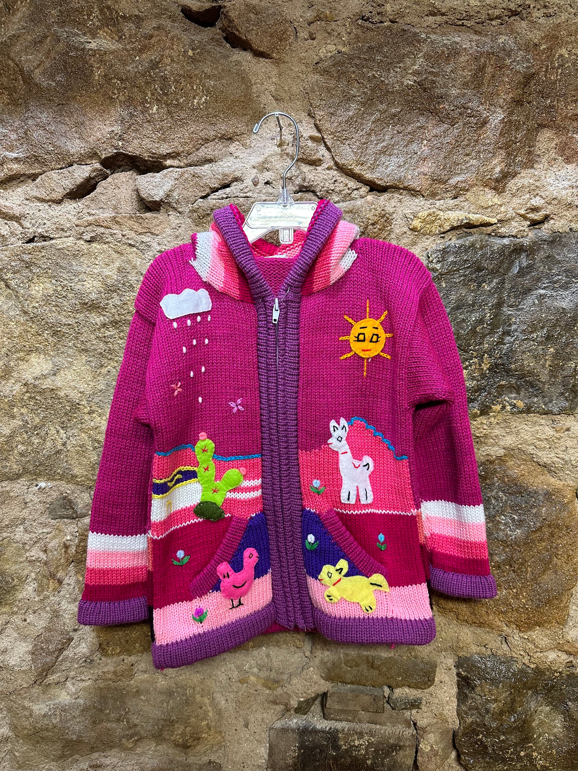 Children's Play Day Sweater! This beautiful, hand-stitched sweater is made with love in Peru and features friendly animals to make any playday special. It will keep your little one warm and cozy while they are out playing and exploring. With vibrant colors and cozy comfort, the Children's Play Day Sweater is perfect for all of your adventures!