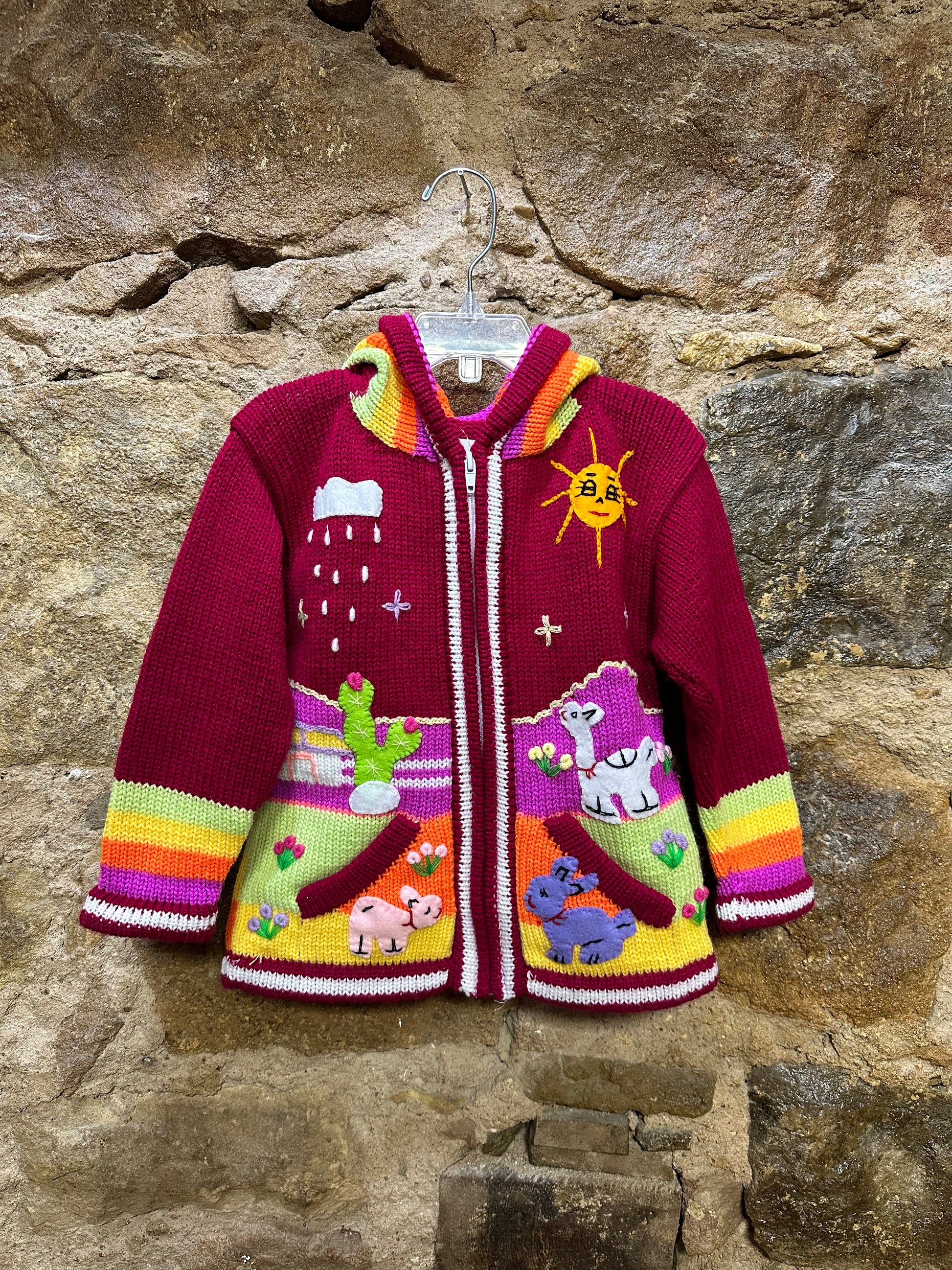 Children's Play Day Sweater! This beautiful, hand-stitched sweater is made with love in Peru and features friendly animals to make any playday special. It will keep your little one warm and cozy while they are out playing and exploring. With vibrant colors and cozy comfort, the Children's Play Day Sweater is perfect for all of your adventures!