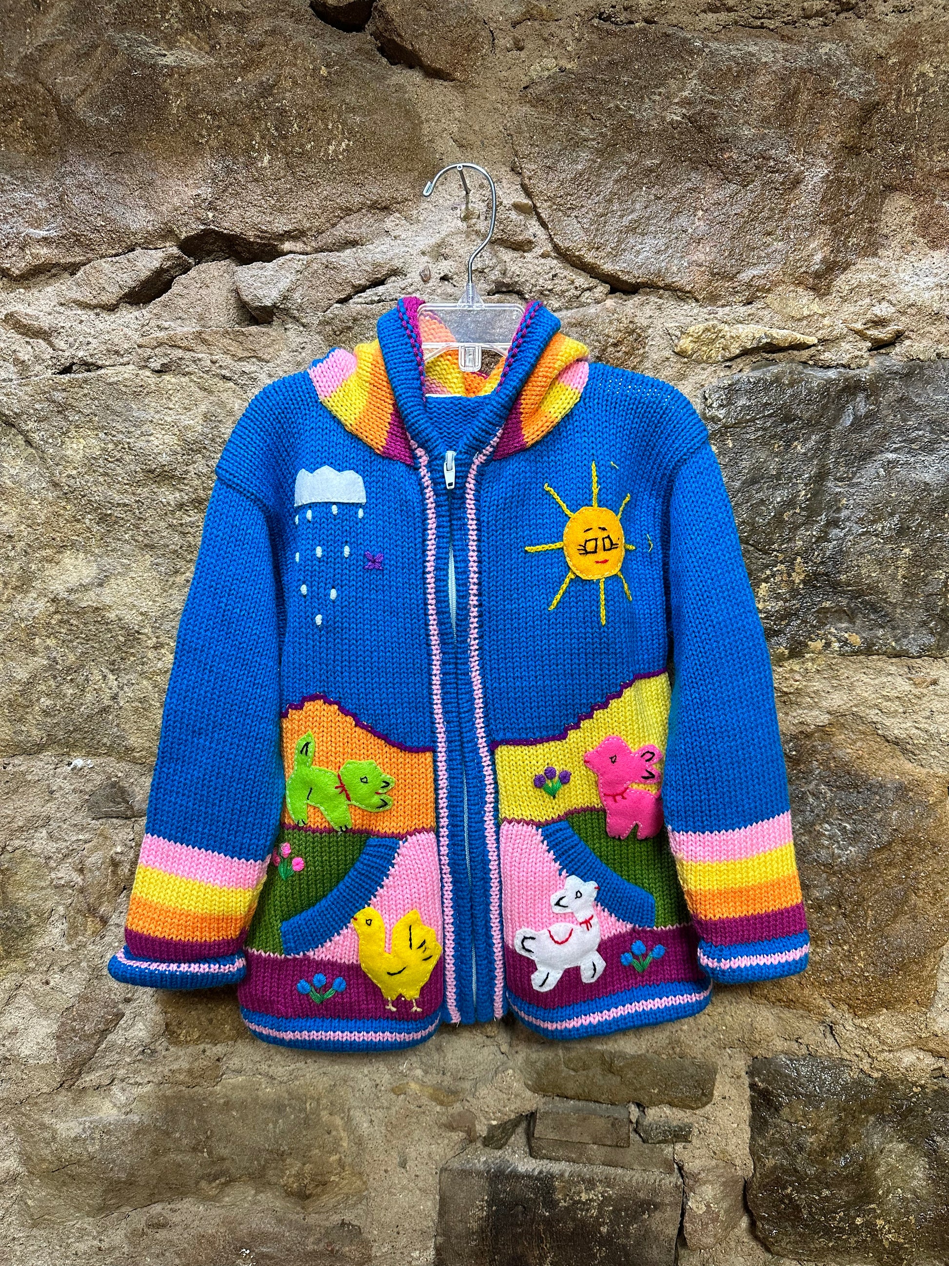 Children's Play Day Sweater! This beautiful, hand-stitched sweater is made with love in Peru and features friendly animals to make any playday special. It will keep your little one warm and cozy while they are out playing and exploring. With vibrant colors and cozy comfort, the Children's Play Day Sweater is perfect for all of your adventures!