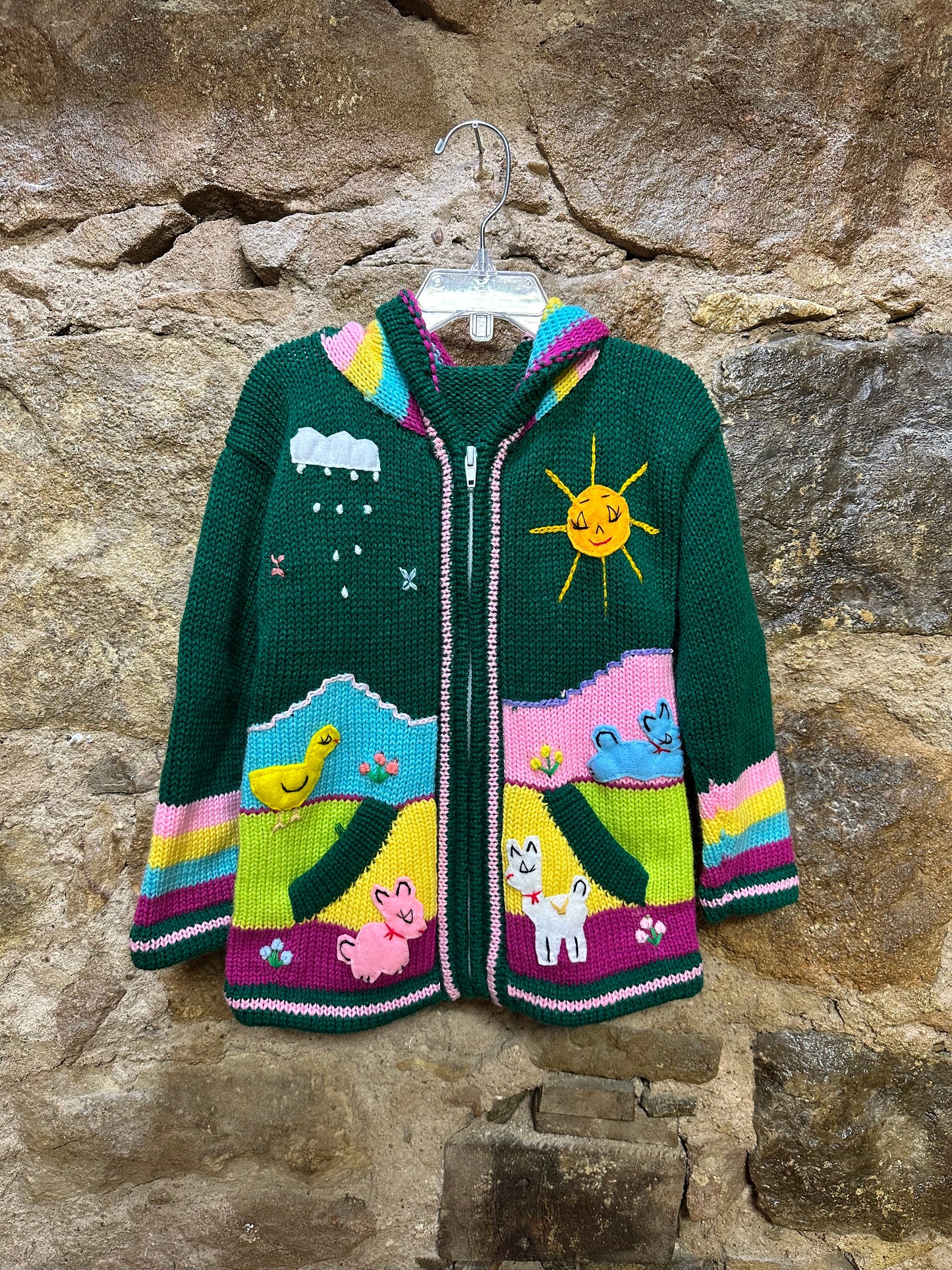 Children's Play Day Sweater! This beautiful, hand-stitched sweater is made with love in Peru and features friendly animals to make any playday special. It will keep your little one warm and cozy while they are out playing and exploring. With vibrant colors and cozy comfort, the Children's Play Day Sweater is perfect for all of your adventures!