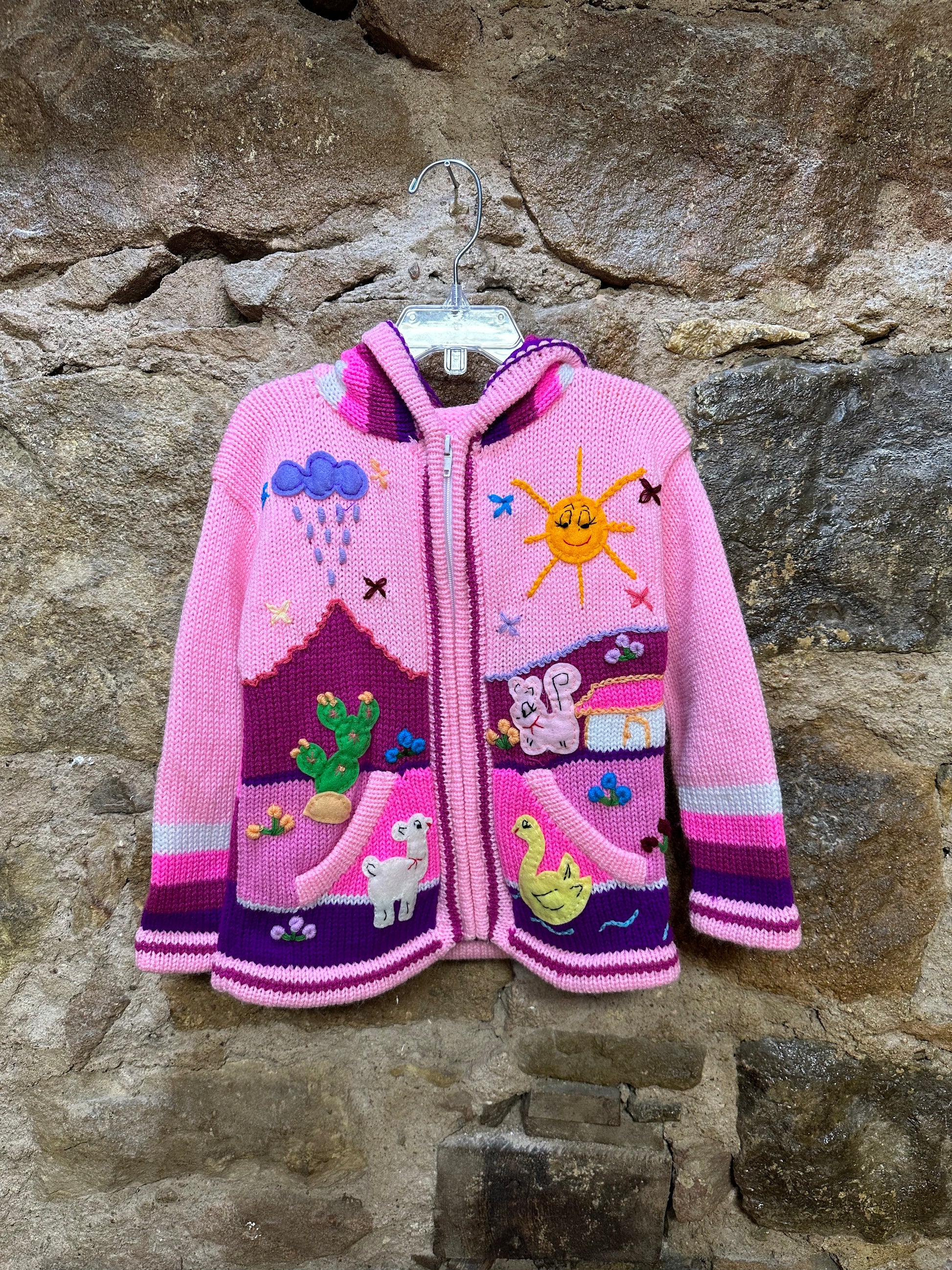 Children's Play Day Sweater! This beautiful, hand-stitched sweater is made with love in Peru and features friendly animals to make any playday special. It will keep your little one warm and cozy while they are out playing and exploring. With vibrant colors and cozy comfort, the Children's Play Day Sweater is perfect for all of your adventures!