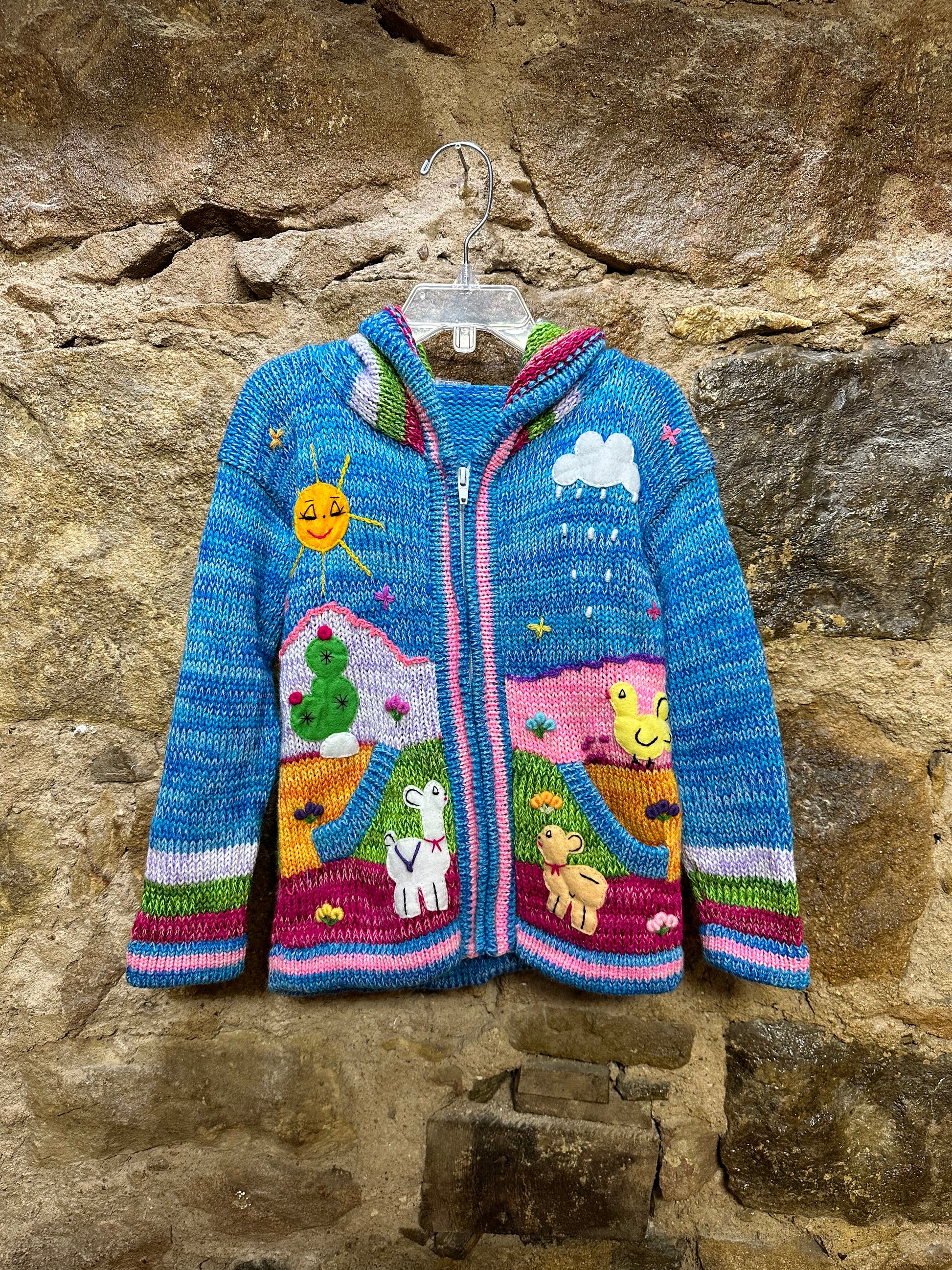 Children's Play Day Sweater! This beautiful, hand-stitched sweater is made with love in Peru and features friendly animals to make any playday special. It will keep your little one warm and cozy while they are out playing and exploring. With vibrant colors and cozy comfort, the Children's Play Day Sweater is perfect for all of your adventures!